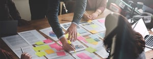 azelis-team-brainstorming-with-notes-and-documents-1440x560px